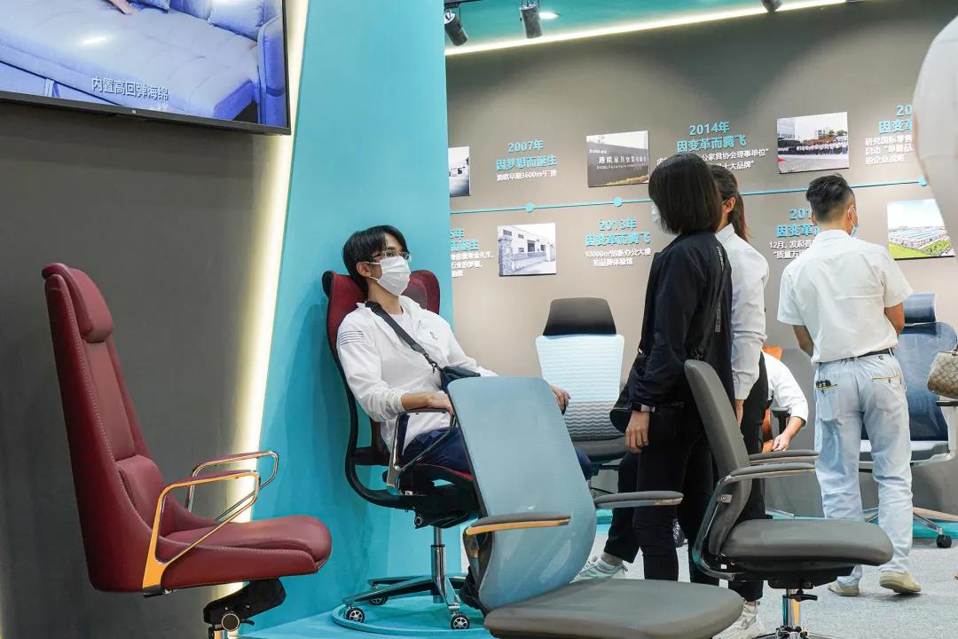 图丨客商们在草莓视频官网在线观看展位现场体验办公坐具的产品性能